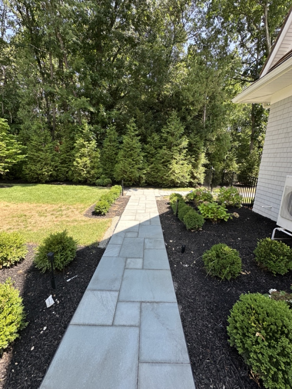 Bluestone walkway along rear of home with privacy plantings
