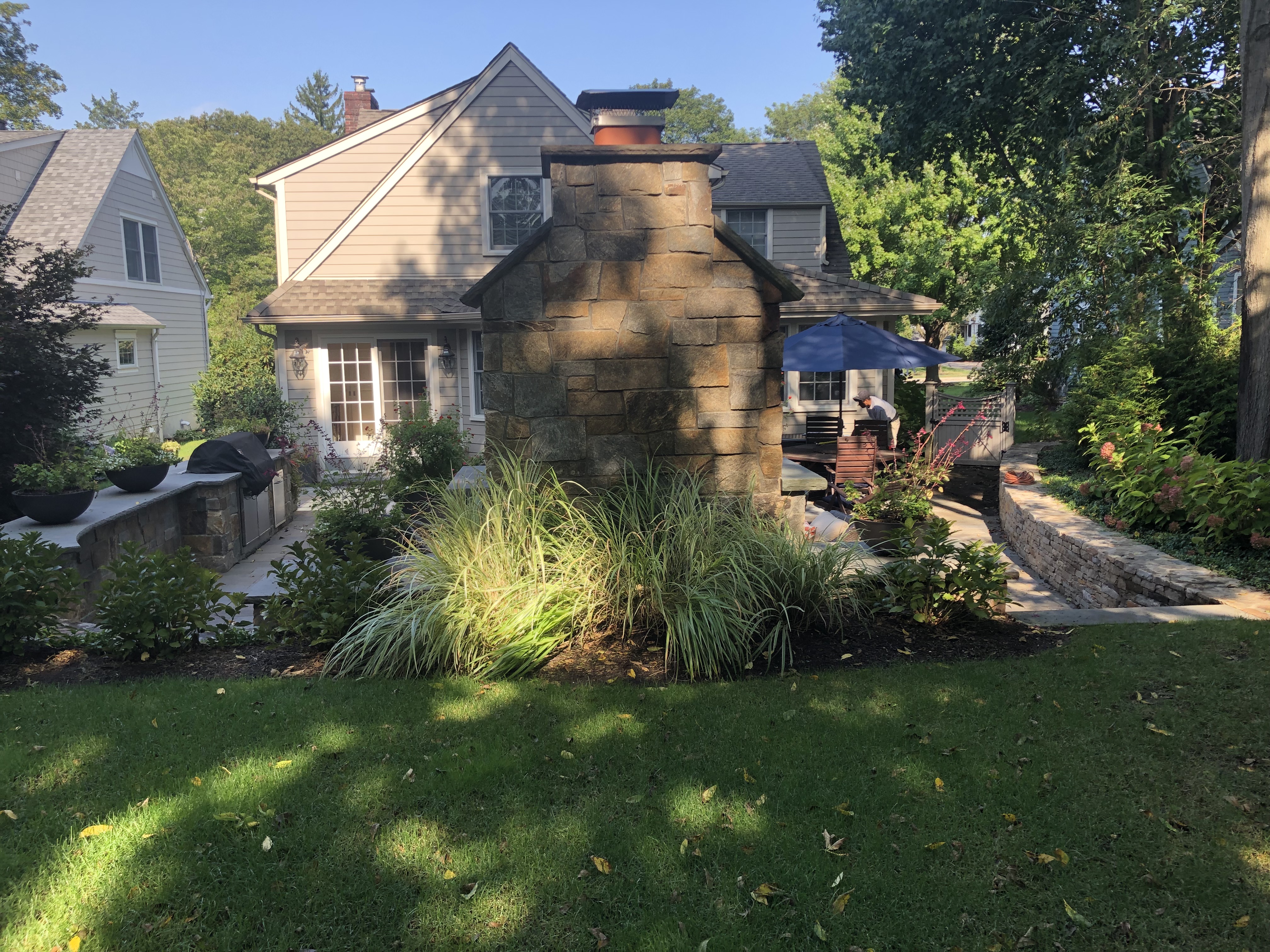 Stone fireplace and seating wall detail with ornamental plantings