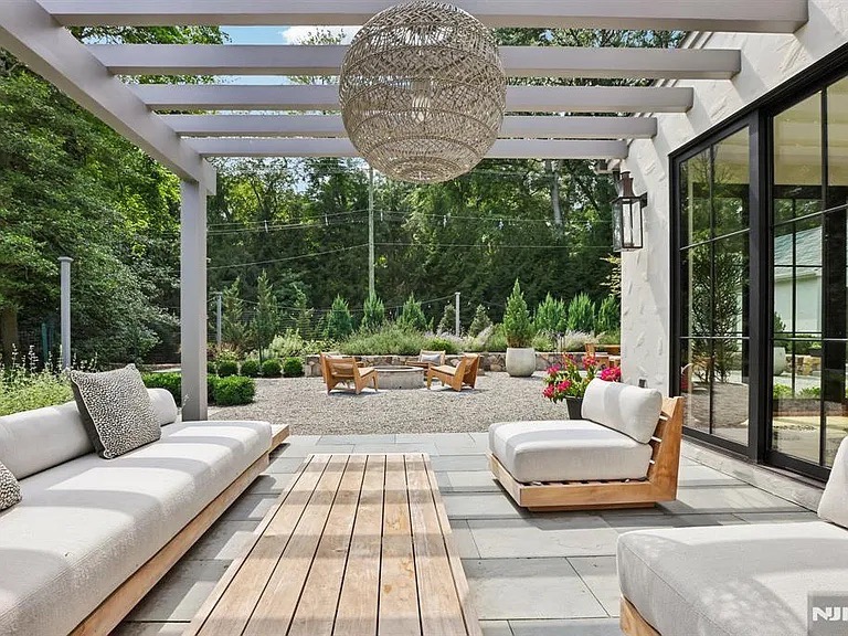 Custom thermal bluestone seating area beneath the covered back patio overlooking the rear courtyard — Ho-Ho-Kus