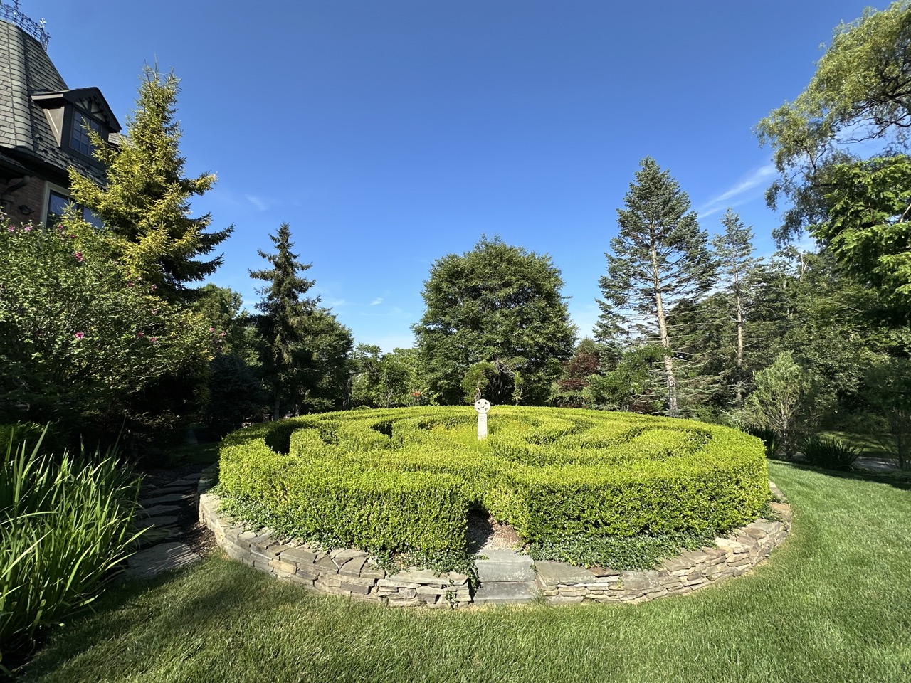 Formal boxwood hedge maze with dry-stack stone border