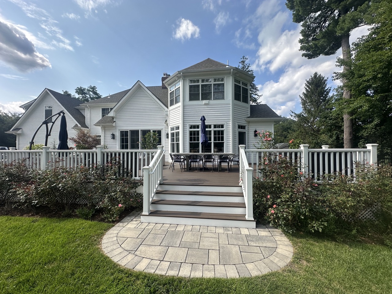 Rear deck and garden with composite steps, paver landing, rose plantings and sunroom facade — Ho-Ho-Kus