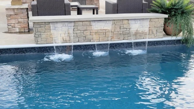 Custom stone waterfall feature cascading into pool